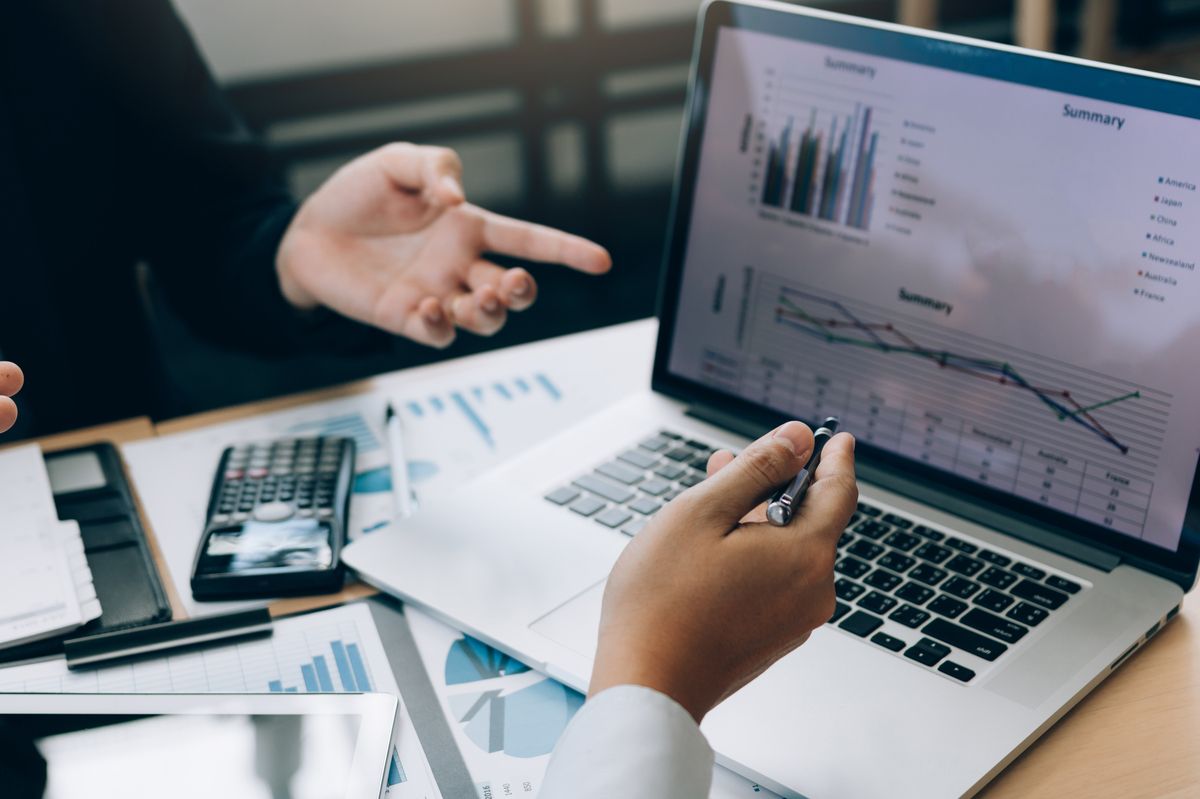 Zwei Personen sitzen vor dem Laptop und schauen sich Statistiken an